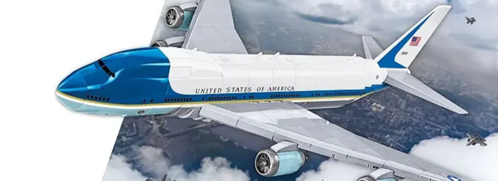 Air Force One airplane flying above clouds with 'United States of America' on the side.
